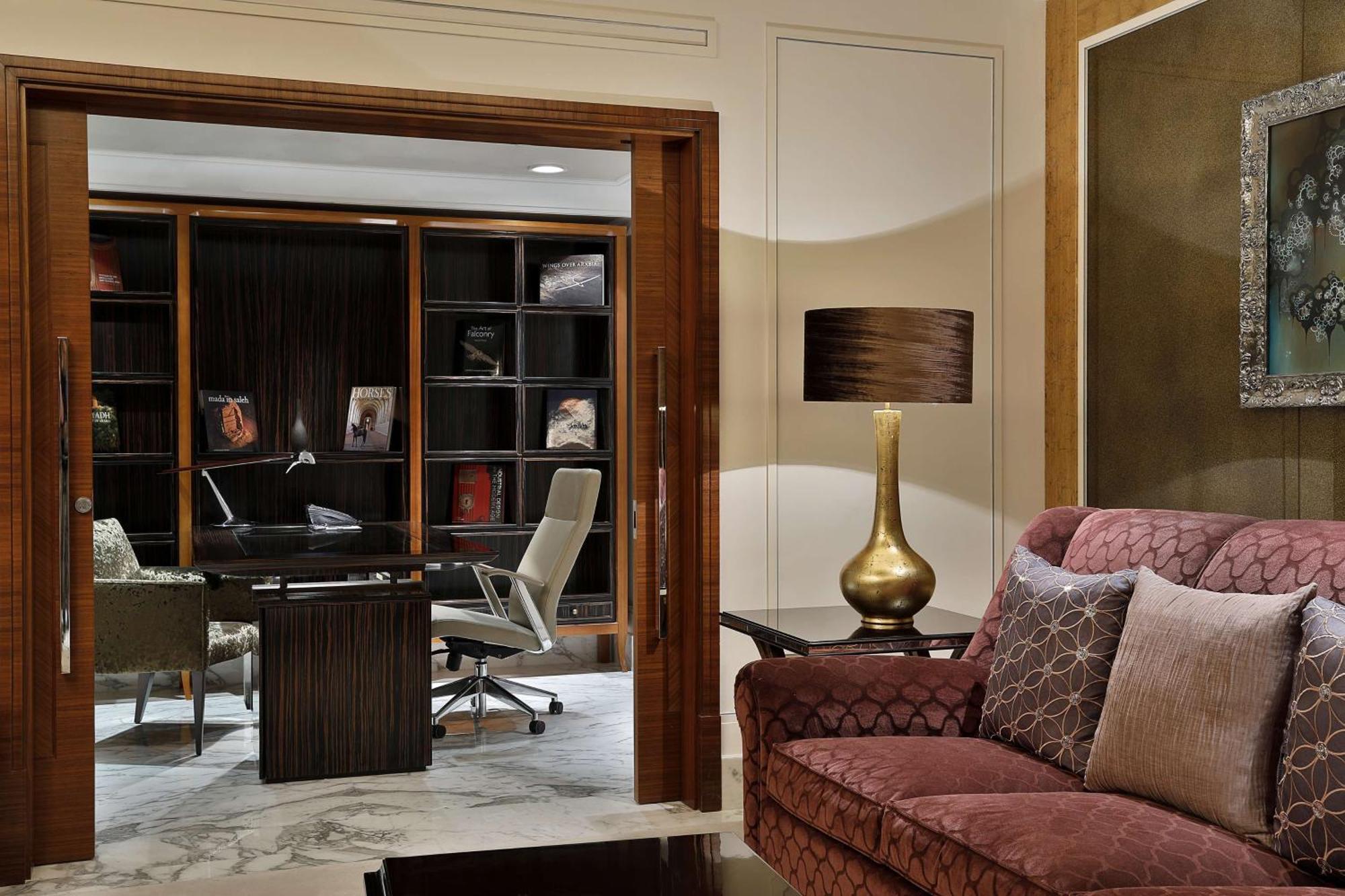 Hilton Riyadh Hotel & Residences Exteriör bild The photo shows a stylish and modern interior space that appears to be a home office or study. In the foreground, there is a comfortable burgundy sofa with decorative pillows. Behind the sofa, there is a doorway leading to the office area, which incl