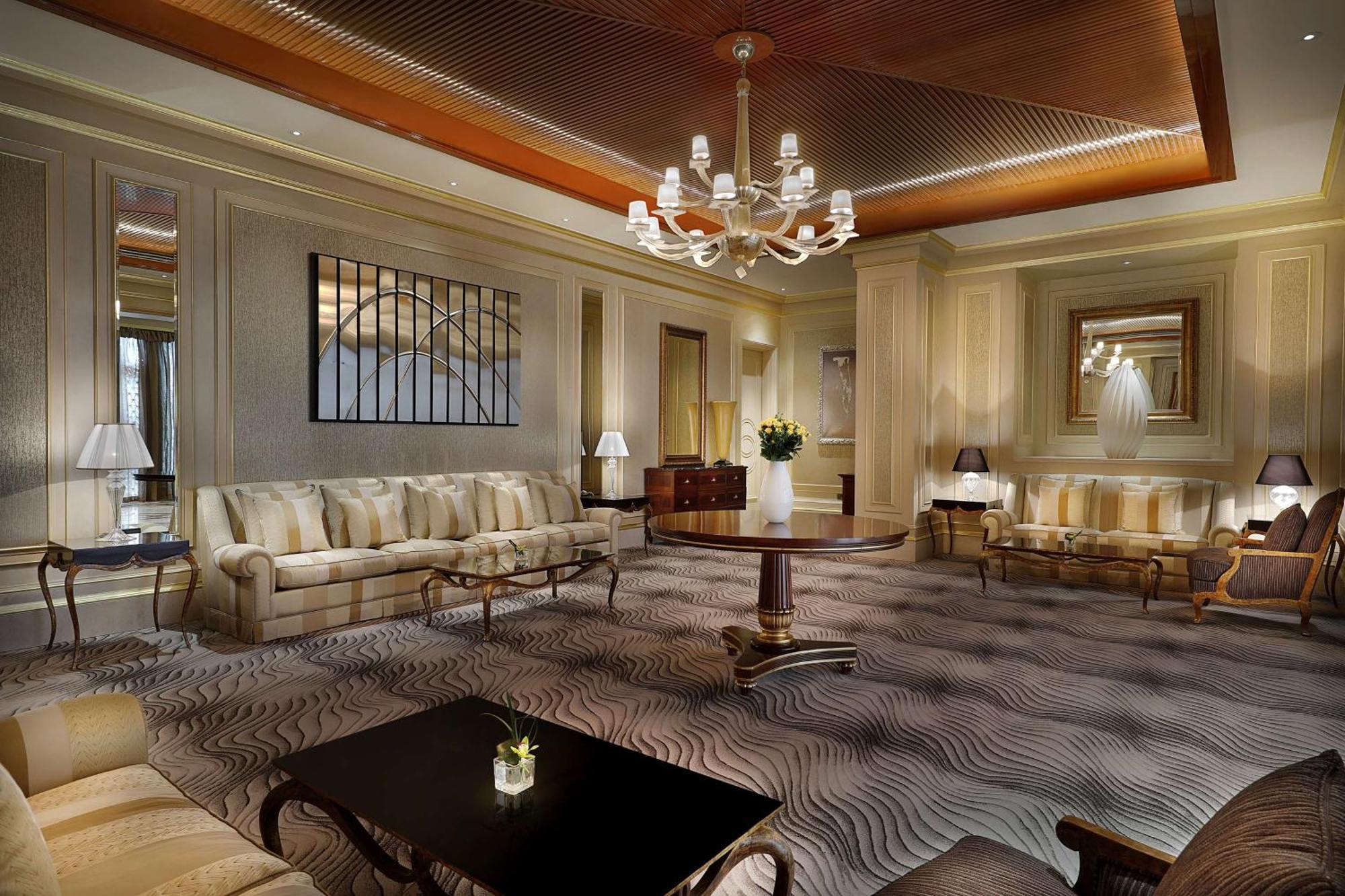 Hilton Riyadh Hotel & Residences Exteriör bild The photo depicts an elegant and well-appointed living room or lounge area. It features a soft color palette with beige and cream tones throughout. 

1. **Furniture**: There are two plush sofas, a round wooden coffee table in the center, and a couple