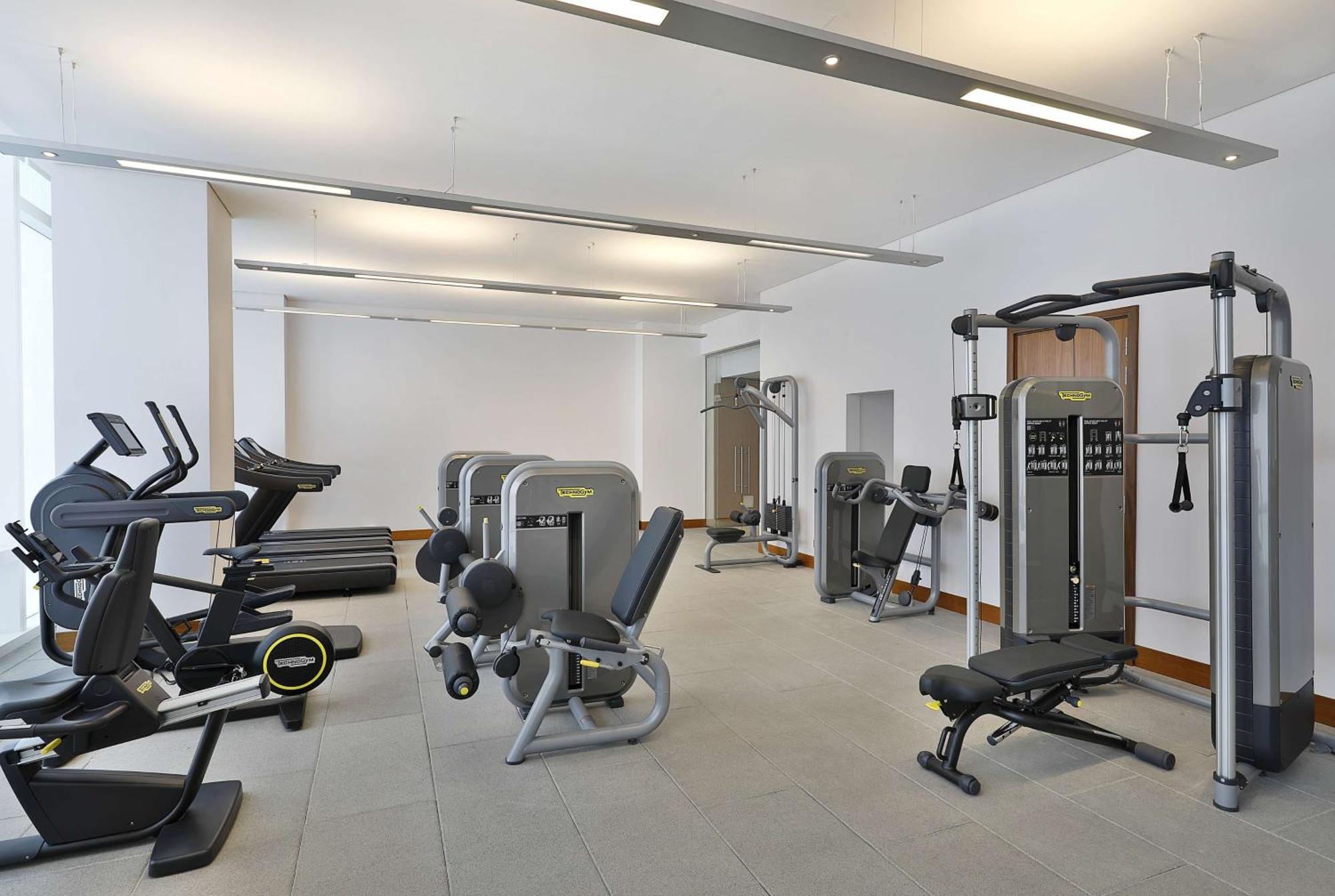 Hilton Riyadh Hotel & Residences Exteriör bild The photo shows a modern gym or fitness center with various exercise equipment. On the left, there are several treadmills, while the center features a range of weight machines. There is a multi-station gym equipment, and a bench press is also visible